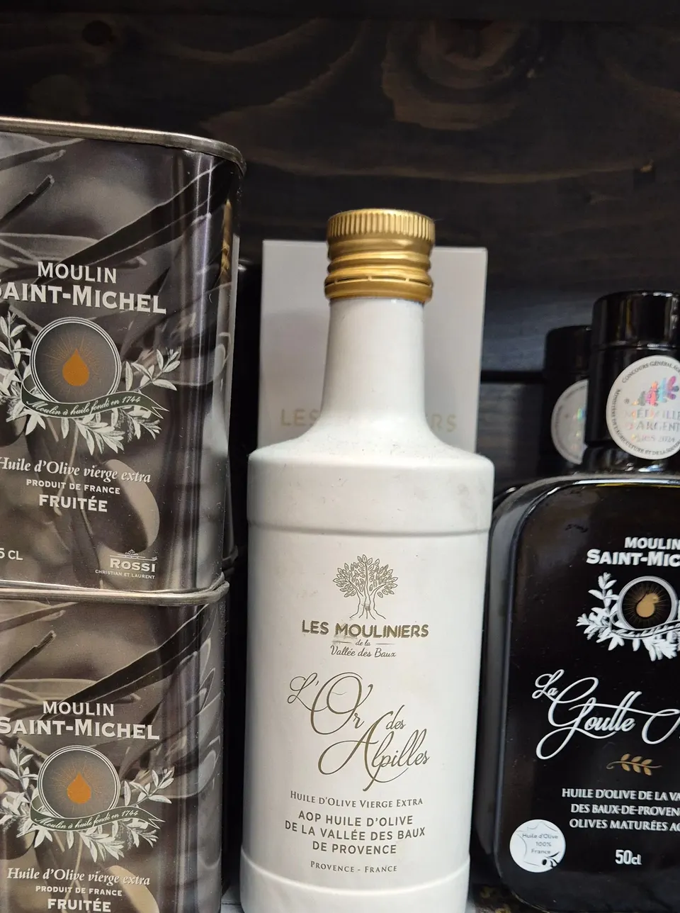 Bouteilles et bidons d'huile d'olive de Provence présentés en rayon