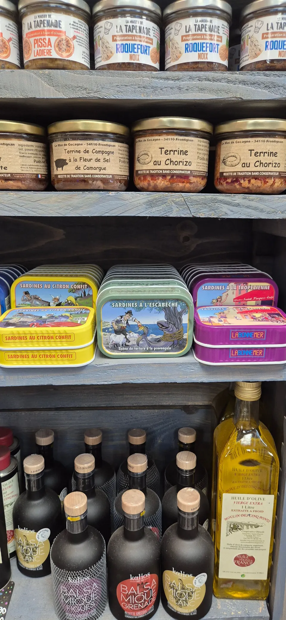 Rayon de tapenades, terrines, boîtes de sardines et huiles d'olive présenté en boutique